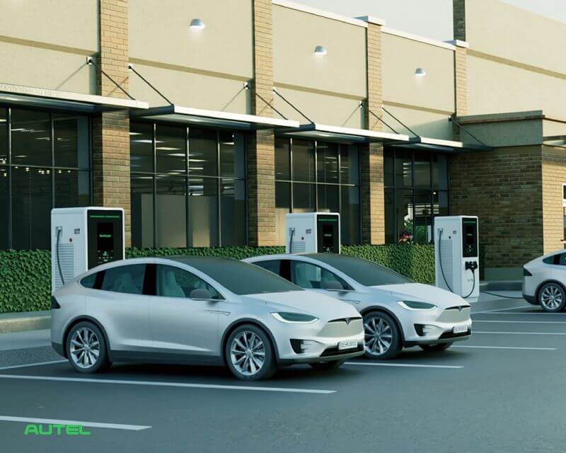 AUTEL DC fast charging stations in front of a commercial building, two electric vehicles charging